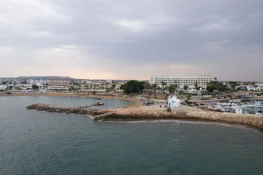 A serene aerial view of Pernera coastline, showcasing the harbor and iconic white church.