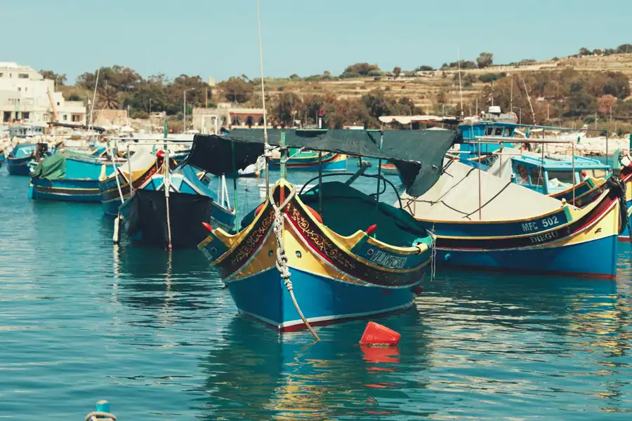Vibrant traditional Maltese boats moored in Marsaxlokk harbor, capturing the charm of the Mediterranean fishing village.